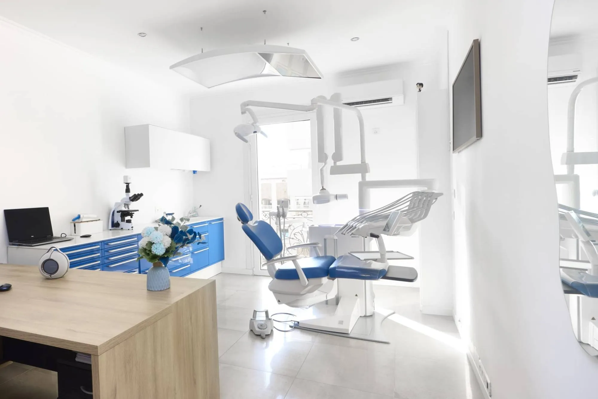 La salle de soins lumineuse du cabinet, avec son fauteuil et son microscope